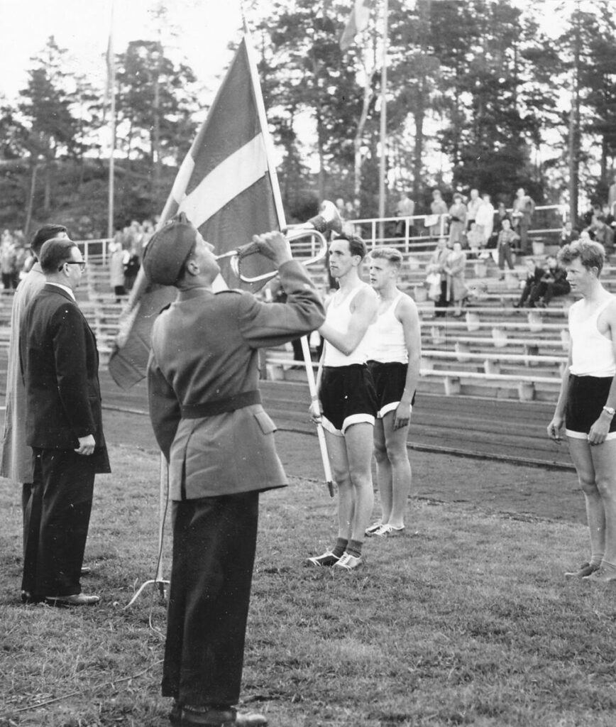 I mörk kostym Erik , Jansson. Skymd där bakom Lennart "Lente" Hagstedt, Trumpetare Militär, Lennart Hurtig tar emot fannan, Till höger i bild Bengt Skagersjö.